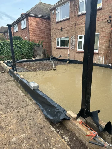 New concrete foundation slab prepared for the rear extension.