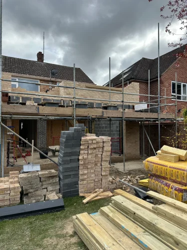Brick and block walls rising across the rear of the Herons Close house.