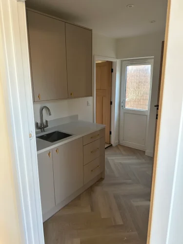 Finished utility room with fitted cabinetry and sink in Eynesbury