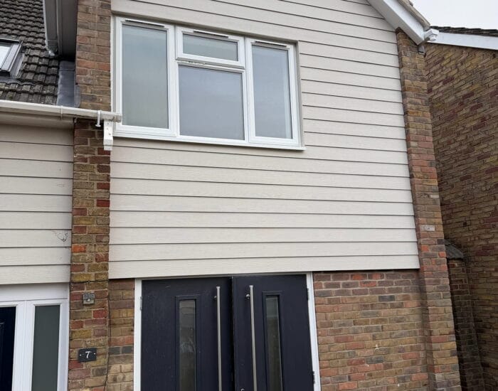 Completed front elevation with cladding, brickwork and new entrance doors at Carisbrooke Road