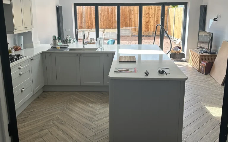 Finished open-plan kitchen with island and bifold doors at Clay Street, Histon