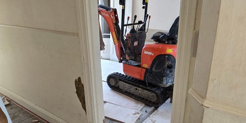 Mini excavator working inside the stripped ground floor of a Victorian house in Cambridge
