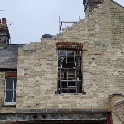 New window opening framed in the yellow gault brick rear elevation of a Victorian house in Cambridge