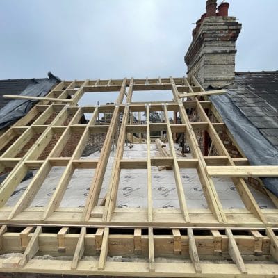 New timber roof structure spanning between gault brick walls during a loft conversion in Cambridge