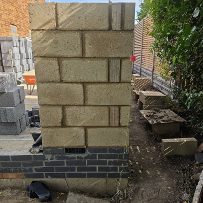 Blockwork pier built up on a blue engineering brick plinth with a weep vent in the plinth course, house extension in Great Shelford