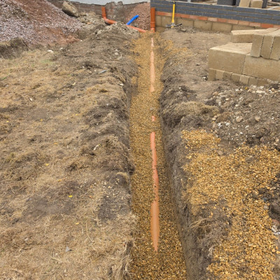 New 110mm foul drainage pipe laid to falls on a pea shingle bed in a trench running towards the house extension, Great Shelford